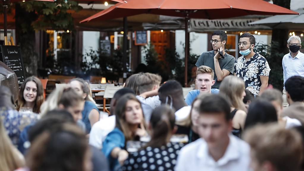 Jugendliche sitzen an Tischen auf der Terrasse eines Cafés. Angesichts steigender Corona-Zahlen hat Frankreichs Premierminister Castex an das Verantwortungsbewusstsein seiner Landsleute appelliert und warnte vor der wachsenden Ausbreitung des Virus im Land. Foto: Jean-Francois Badias/AP/dpa