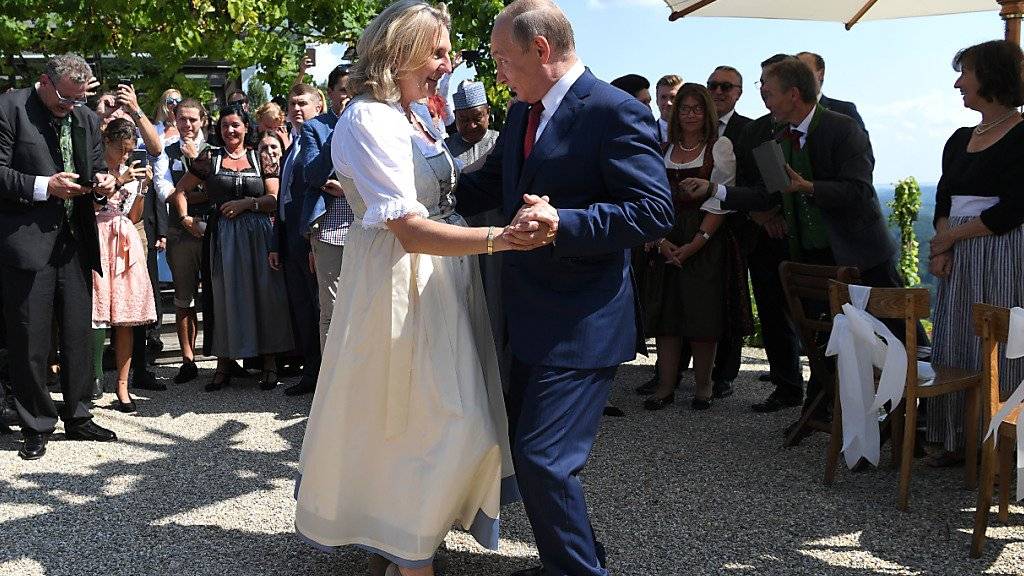 Österreichs Aussenministerin Karin Kneissl (links) und der russische Präsident Wladimir Putin (rechts) tanzen an der Hochzeit.