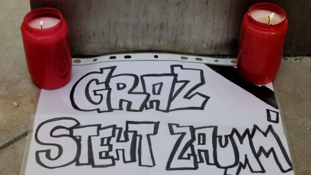 Kerzen stehen neben einem Stück Papier mit der Aufschrift «Graz steht zusammen». Ein 21-Jähriger aus dem Raum Graz hat nach Angaben der Behörden die tödlichen Schüsse an einem Gymnasium im österreichischen Graz abgegeben. Foto: Heinz-Peter Bader/AP/dpa