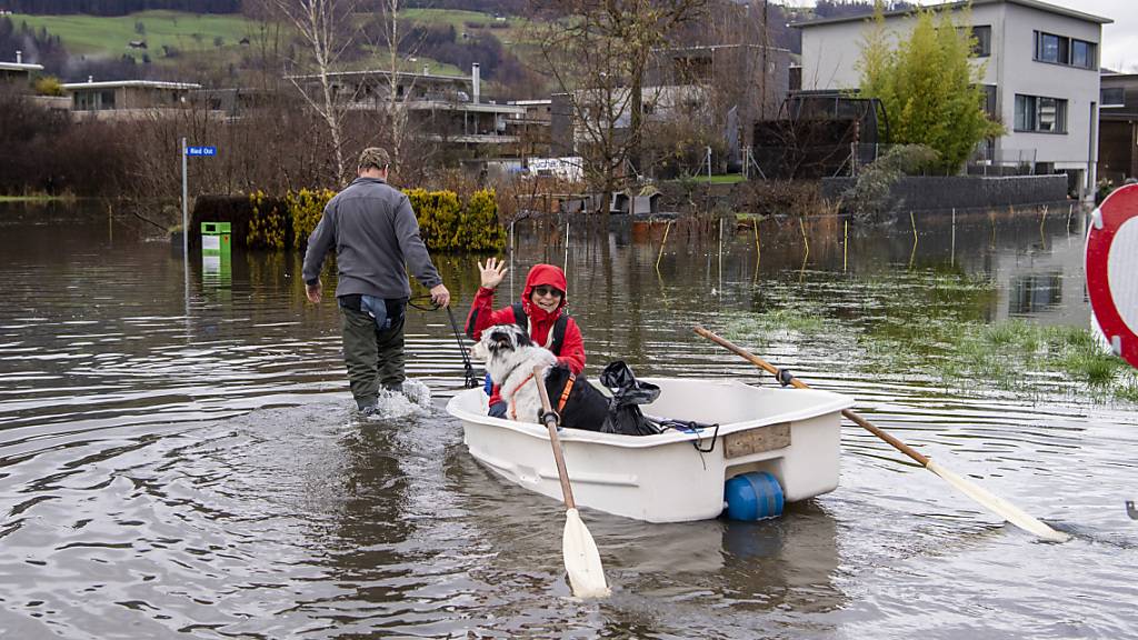 Quartierbewohner paddeln mit ihrem Boot zu ihrer Wohnung im Quartier in Giswil OW am Sarnersee.