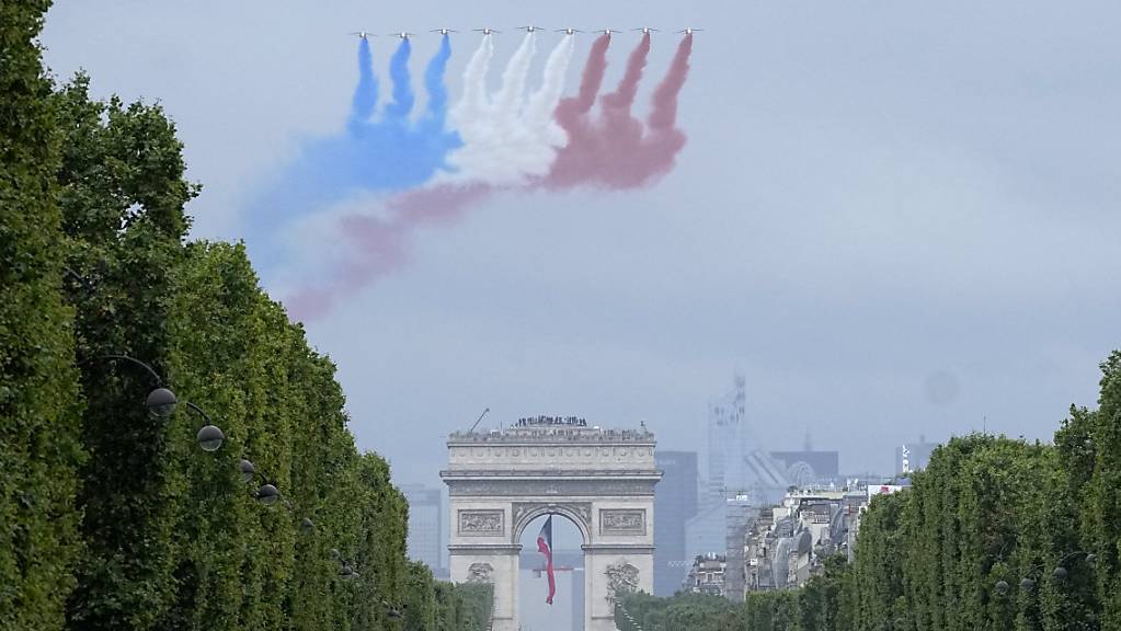 Jets der offiziellen Kunstflugstaffel der französischen Luftwaffe fliegen bei der Militärparade zum Tag der Bastille über die Champs-Élysées. Foto: Michel Euler/Pool AP/dpa
