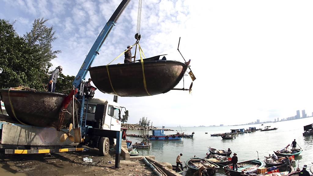 Menschen bewegen Fischerboote in Vorbereitung auf den Sturm Molave. In Vietnam bereiten sich die Behörden darauf vor, 1,2 Millionen Menschen vor einem neuen Tropensturm in Sicherheit zu bringen. Foto: Tran Le Lam/VNA/AP/dpa