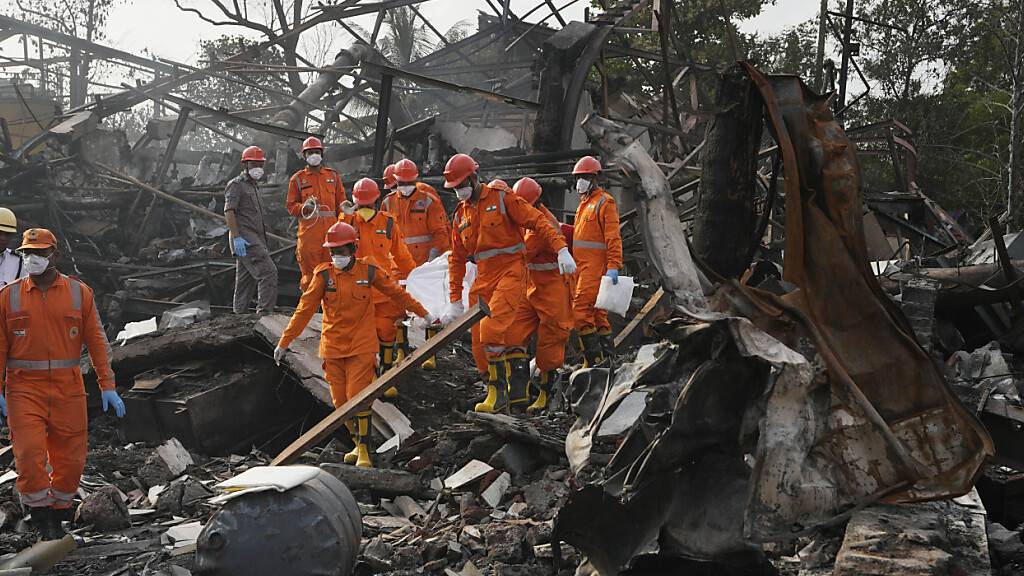 dpatopbilder - Rettungskräfte tragen ein Todesopfer nach einer Explosion und einem Brand in einer Chemiefabrik bei Mumbai. Foto: Rajanish Kakade/AP