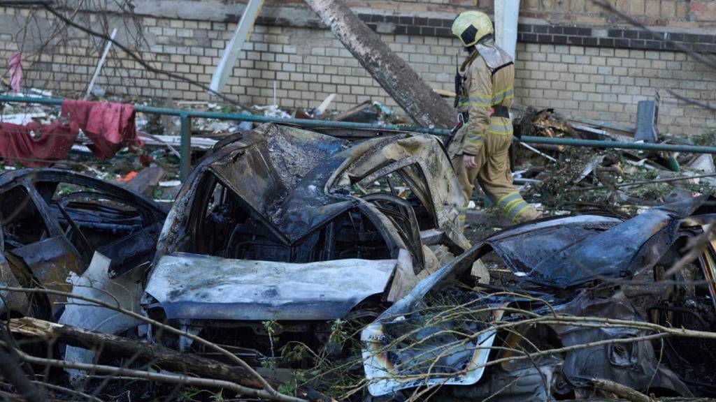 dpatopbilder - Einer der Feuerwehrleute geht am frühen Montag, 23. Juni 2025, an zerstörten Autos in Kiew vorbei. Foto: Efrem Lukatsky/AP/dpa