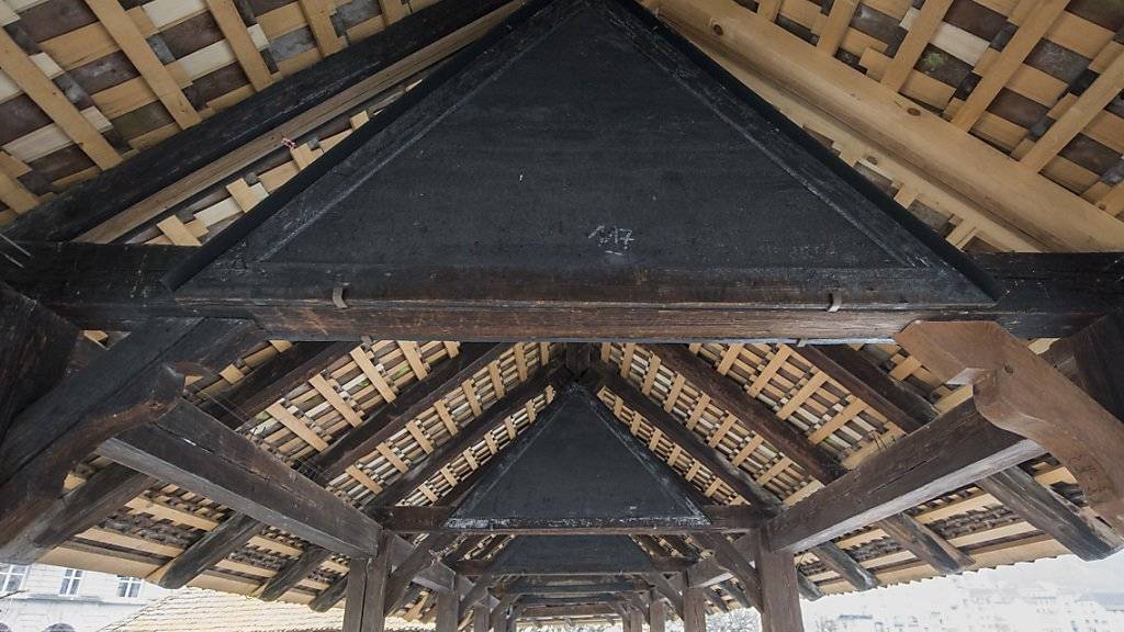 Die heute vor 25 Jahren abgebrannte Luzerner Kapellbrücke war rasch wieder aufgebaut. Wie mit den verbrannten Bildern im Dachgiebel umgegangen werden soll, wird aber auch heute noch diskutiert.