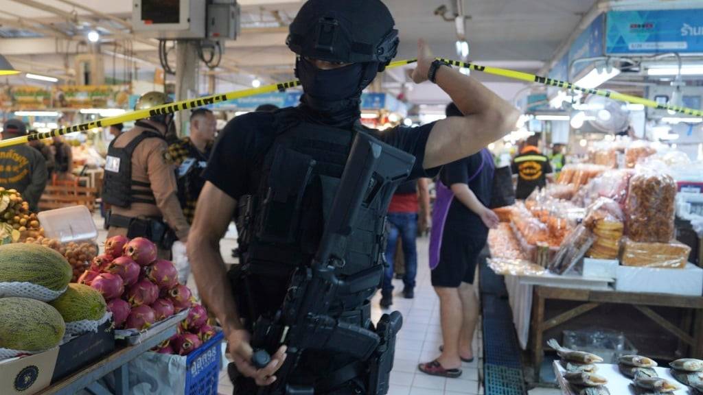 dpatopbilder - Polizisten einer Spezialeinheit an einem Tatort auf einem Markt in dem laut Polizei sechs Menschen durch einer Schüsse ums Leben gekommen sind. Foto: Nava Sangthong/AP/dpa