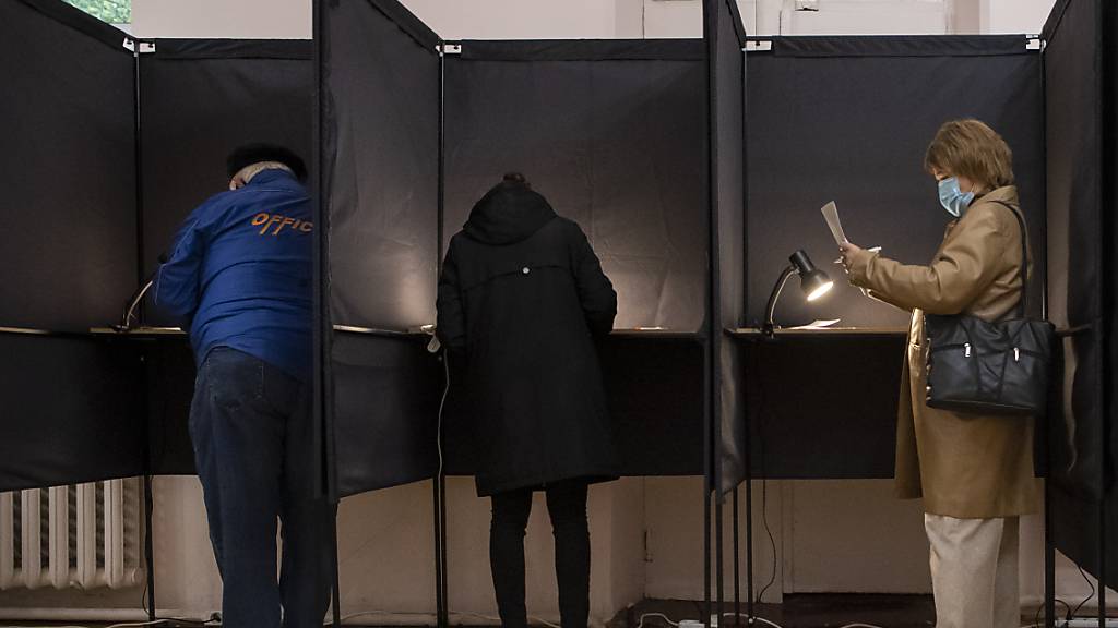 Wähler geben ihre Stimmen in Wahlkabinen ab. Foto: Mindaugas Kulbis/AP/dpa