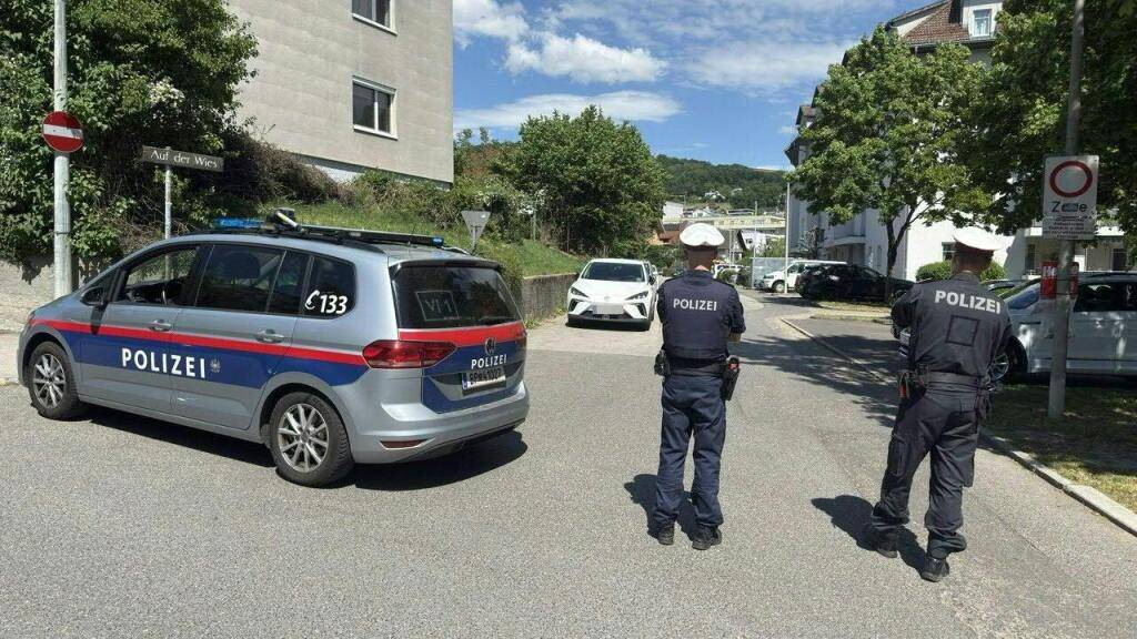 HANDOUT - Polizisten sind in der Nähe des Tatorts in Linz im Einsatz. Foto: Fotokerschi/Werner Kerschbaummay/APA/dpa - ACHTUNG: Nur zur redaktionellen Verwendung im Zusammenhang mit der aktuellen Berichterstattung und nur mit vollständiger Nennung des vorstehenden Credits. Ein KEnnzeichen wurde vom Handoutgeber gepixelt.