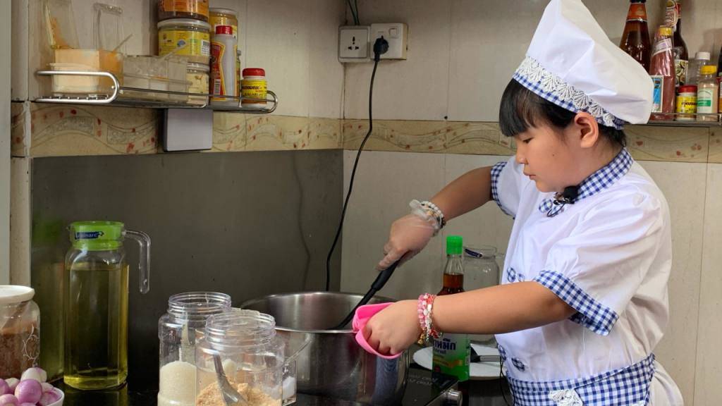 HANDOUT - Die achtjährige Moe Myint May Thu beim Kochen in ihrer Küche. Sie ist während des Lockdowns in Myanmar zu einer kleinen Starköchin geworden. Foto: --/privat/dpa - ACHTUNG: Nur zur redaktionellen Verwendung im Zusammenhang mit der aktuellen Berichterstattung und nur mit vollständiger Nennung des vorstehenden Credits