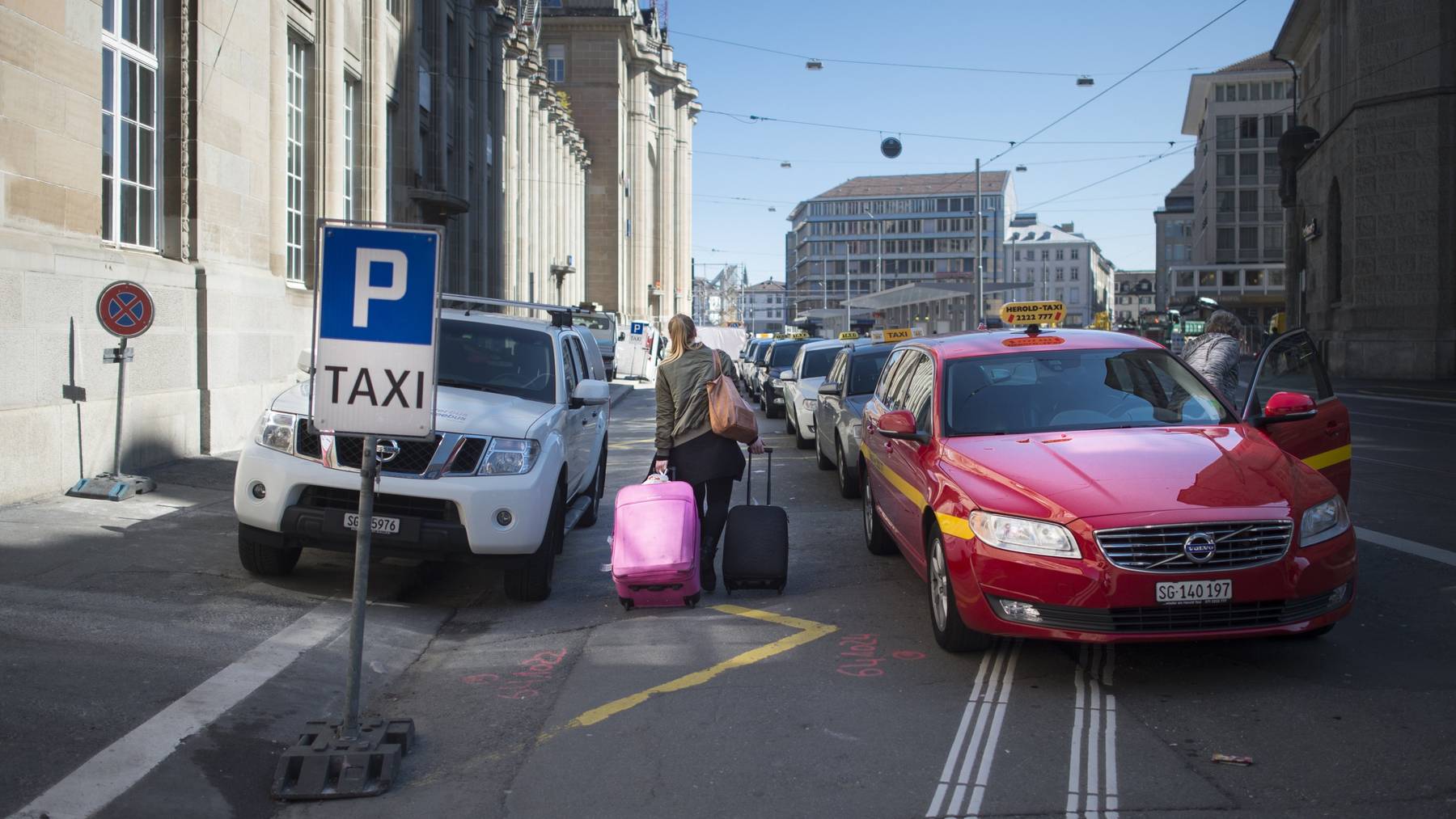 Eine Frau sucht sich beim Bahnhof St.Gallen ein Taxi aus.