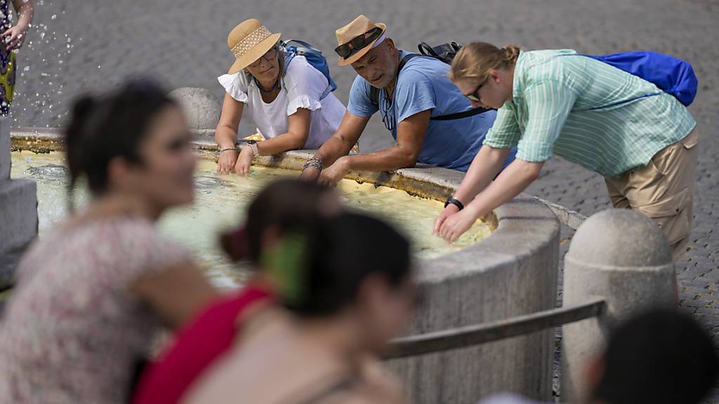 Touristen erfrischen sich in Rom: Eine intensive Hitzewelle hat Italien erreicht. Foto: Andrew Medichini/AP