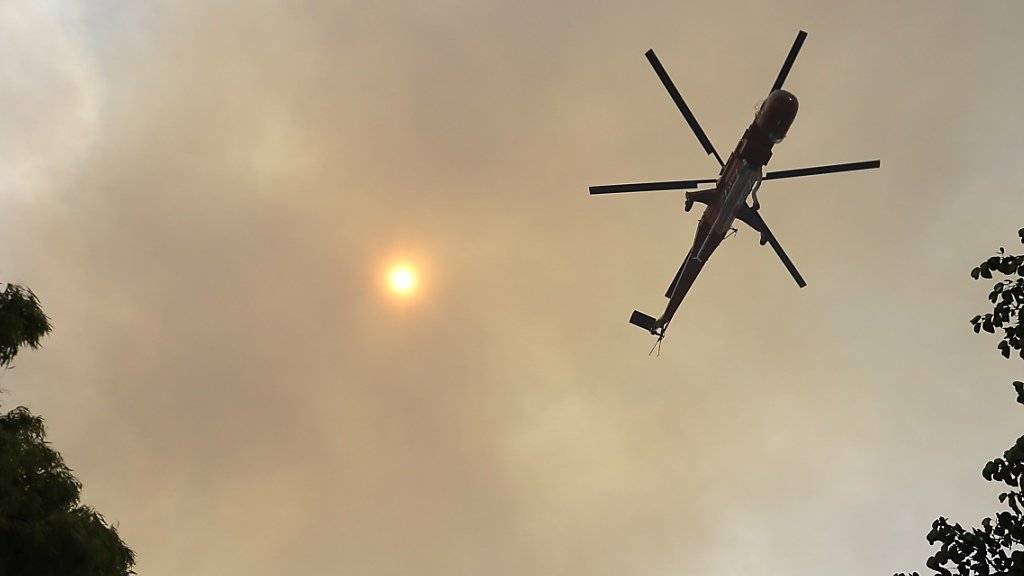 Ein Helikopter fliegt durch den Rauch auf der griechischen Insel Euböa - dort wütete seit Tagen ein Waldbrand, der nun aber weitgehend unter Kontrolle ist.