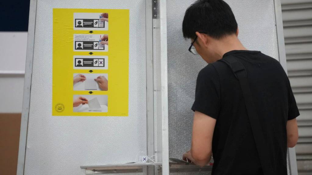 Ein singapurischer Wähler gibt seine Stimme bei den Parlamentswahlen in einem Wahllokal in Singapur ab. Foto: Vincent Thian/AP/dpa