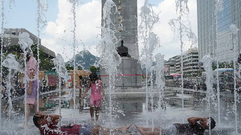 dpatopbilder - Jugendliche suchen in einem öffentlichen Brunnen Abkühlung. Foto: Ahn Young-joon/AP