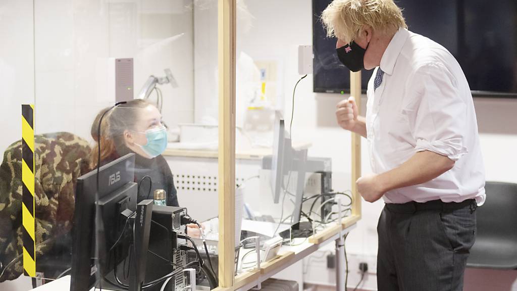 Boris Johnson, Premierminister von Großbritannien, spricht mit einer Mitarbeiterin während er ein Corona-Impfzentrum besucht. Foto: Geoff Pugh/Daily Telegraph/PA Wire/dpa