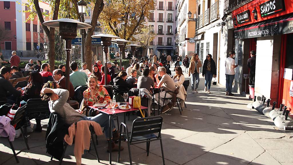 PRODUKTION - Menschen sitzen auf der Terrasse einer Bar im Zentrum von Madrid. Foto: Juan Carlos Rojas/dpa