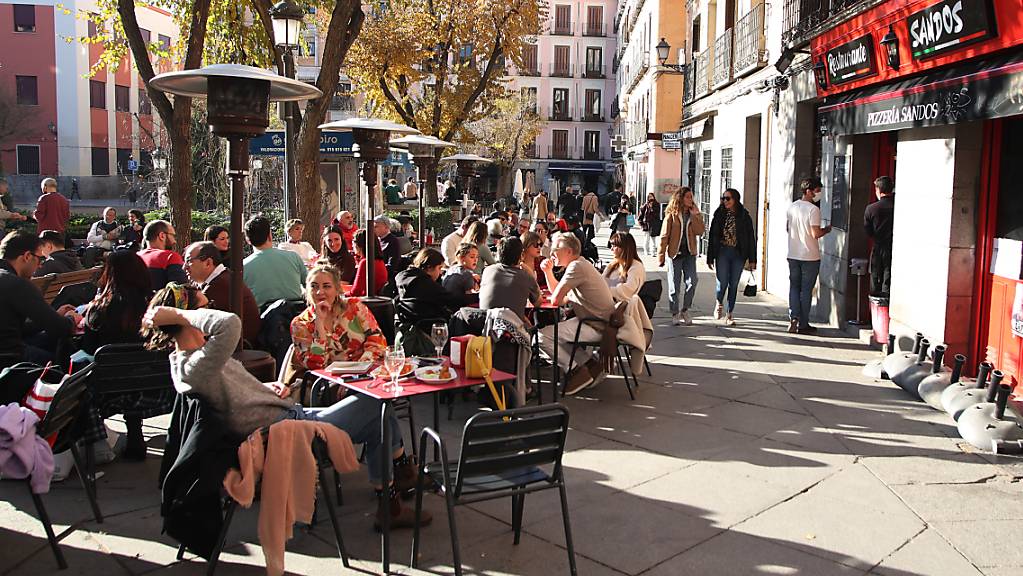 PRODUKTION - Menschen sitzen auf der Terrasse einer Bar im Zentrum von Madrid. Foto: Juan Carlos Rojas/dpa
