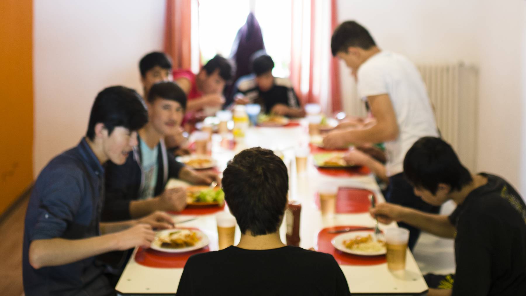 Unbegleitete minderjaehrige Asylsuchende (UMA) sitzen beim Mittagessen.