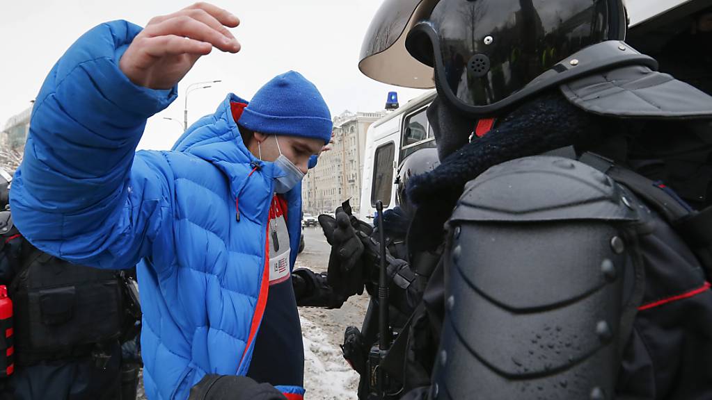 Polizisten durchsuchen einen Mann während einer Demonstration gegen die Inhaftierung des Oppositionsführers Nawalny. Foto: Alexander Zemlianichenko/AP/dpa