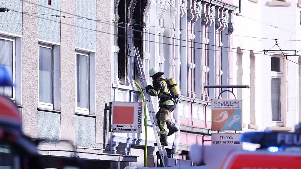 ARCHIV - Ein Feuerwehrmann klettert an einem Haus, in dem es gebrannt hat, auf einer Leiter. Der Großbrand in einem Mehrfamilienhaus in Solingen mit vier Toten ist nach einem vorläufigen Gutachten auf vorsätzliche Brandstiftung zurückzuführen. Foto: David Young/dpa