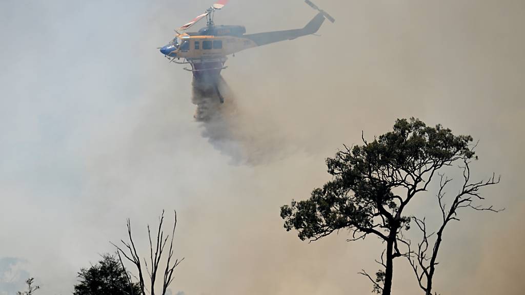 A water-bombing helicopter is seen fighting bushfires near the town of Dalveen, Queensland, Thursday, November 2, 2023.  A cool change may be forecast but Queensland firefighters will remain on high alert as blazes continue to threaten homes across the state. (AAP Image/Darren England) NO ARCHIVING