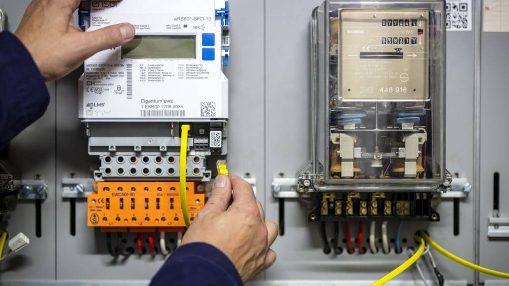 Ein Zählermonteur installiert einen Smart Meter-Stromzähler neben einem alten Stromzähler. (Symbolbild)