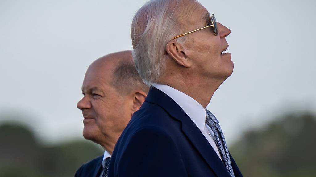 ARCHIV - US-Präsident Joe Biden (r) beobachtet neben Bundeskanzler Olaf Scholz (SPD), Fallschirmspringer beim Gipfeltreffen der G7-Staaten. Foto: Michael Kappeler/dpa