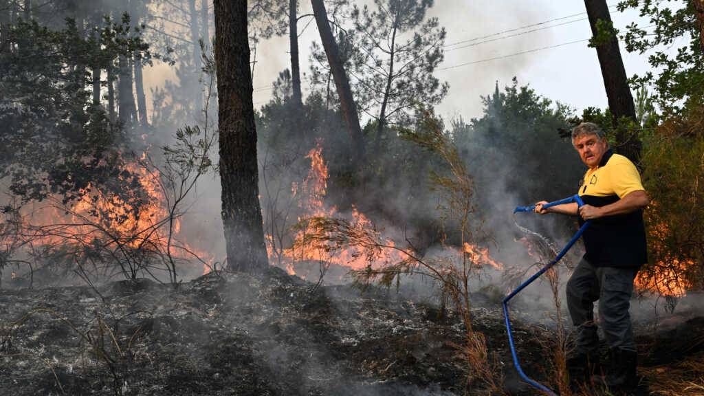 Ein Anwohner löscht in der Nähe von Marcheprime vor den Toren von Bordeaux mit einem Schlauch die Flammen eines Waldbrands. Foto: Emma Da Silva/AP/dpa