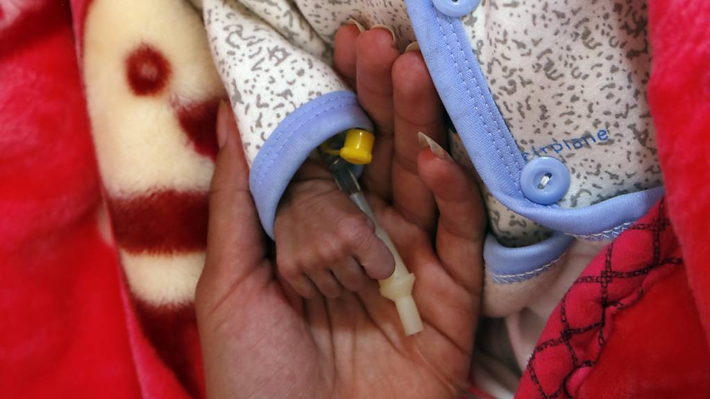 ARCHIV - Eine Frau hält das winzige Händchen ihres Babys, das auf der Station für unterernährte Kinder in einem Krankenhaus medizinisch versorgt wird. Die Vereinten Nationen legen am Montag, 13.07.2020 ihren neuen Bericht zur Welternährung mit den Zahlen zu Hunger und Unterernährung vor. Foto: Mohammed Mohammed/XinHua/dpa