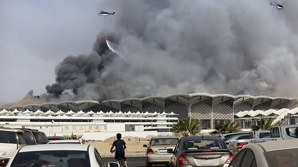 Löschhelikopter bekämpfen ein Feuer im neuen Bahnhof für Hochgeschwindigkeitszüge in der saudiarabische Stadt Dschidda.