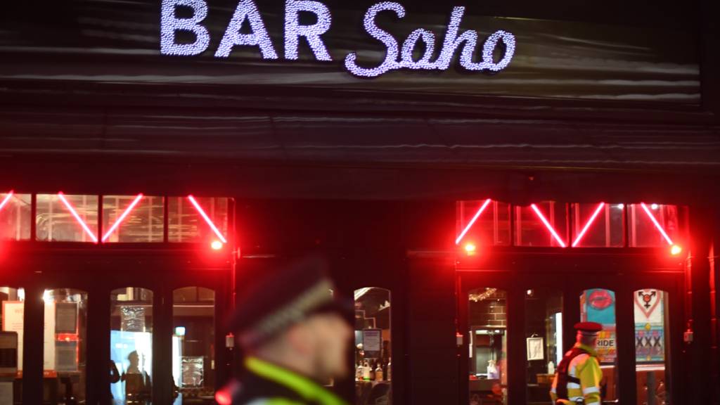 Polizeibeamte stehen vor der Bar Soho in London. Derzeit fehlen in der britischen Club-Branche die Türsteher.