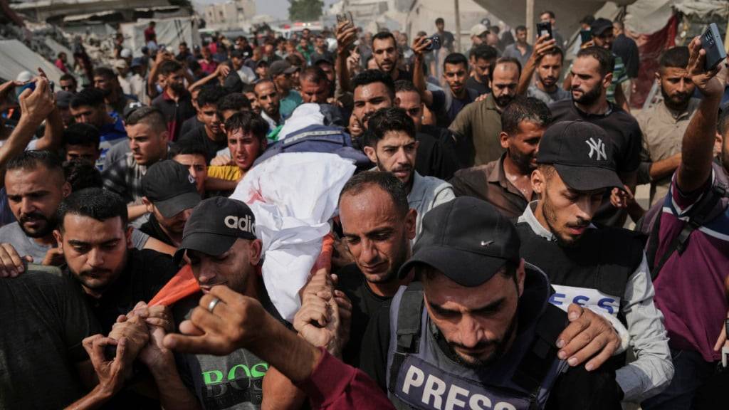ARCHIV - Palästinenser tragen den Leichnam des Al-Dschasira-Korrespondenten Anas al-Scharif, der zusammen mit anderen Journalisten bei einem israelischen Luftangriff getötet wurde, während seiner Beisetzung vor dem Schifa-Krankenhaus. Foto: Jehad Alshrafi/AP/dpa