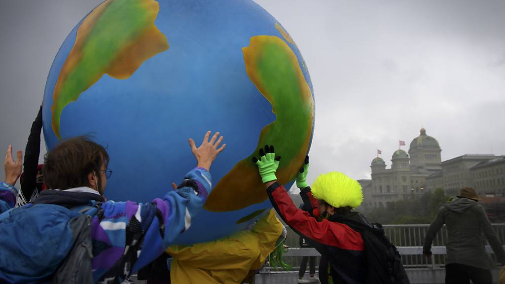 Klimaaktivisten protestieren mit einer aufblasbare Weltkugel während ihrer Aktionswoche Rise up for Change am 25. September 2020 in Bern.