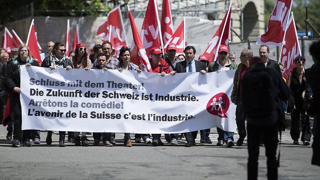 Mitglieder der Unia reichen ein Manifest zuhanden des Bundesrates ein und tragen ein Transparent mit der Aufschrift «Schluss mit dem Theater! Die Zukunft der Schweiz ist Industrie» sowie Unia-Flaggen.