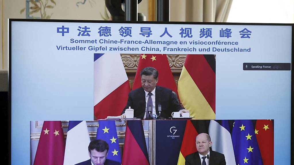 Ein Monitor zeigt Emmanuel Macron (unten,l), Präsident von Frankreich, Bundeskanzler Olaf Scholz (SPD, unten,r) und Xi Jinping (oben), Präsidenten von China, während einer Videokonferenz zur Ukraine-Krise. Foto: Benoit Tessier/Reuters Pool/AP/dpa