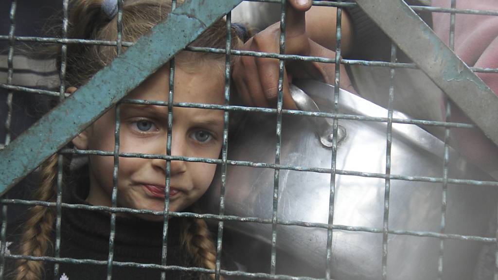 Ein palästinensisches Kind steht im Flüchtlingslager im Gazastreifen an, um kostenlose Mahlzeiten zu erhalten. Foto: Mahmoud Essa/AP/dpa