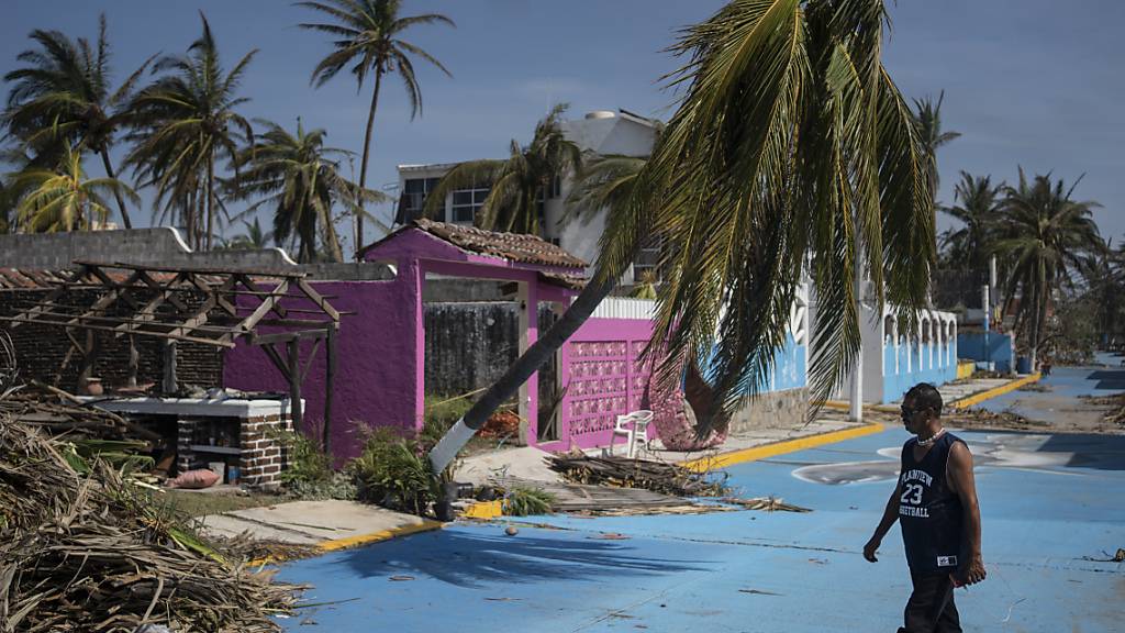 dpatopbilder - Ein Mann geht an einem beschädigten Gebiet nach Hurrikan «Otis» vorbei. Foto: Felix Marquez/AP