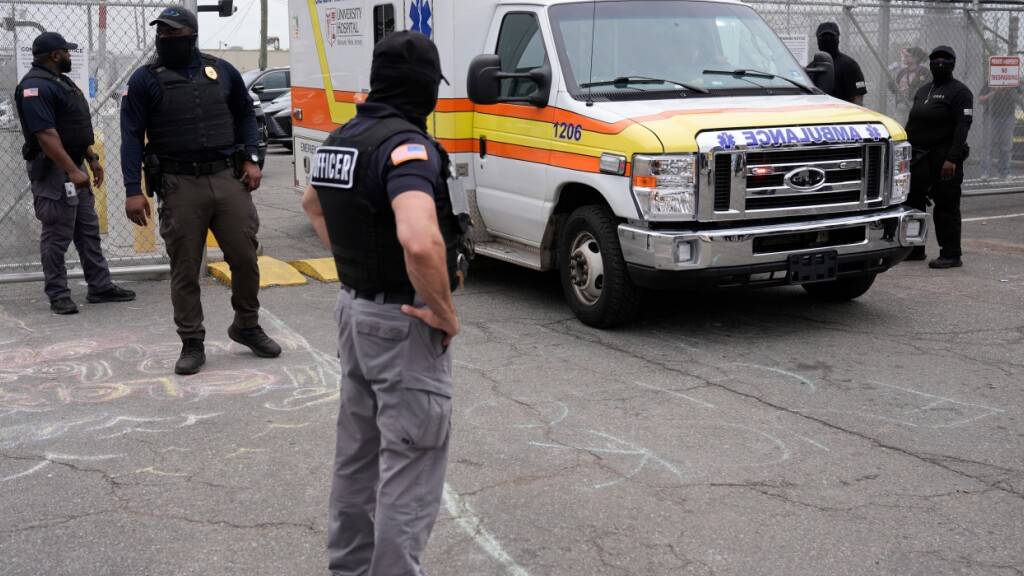 ARCHIV - Beamte der US-Einwanderungsbehörde (ICE) stehen vor der Haftanstalt Delaney Hall, als ein Krankenwagen das Gelände verlässt. Foto: Seth Wenig/AP/dpa/Archivbild