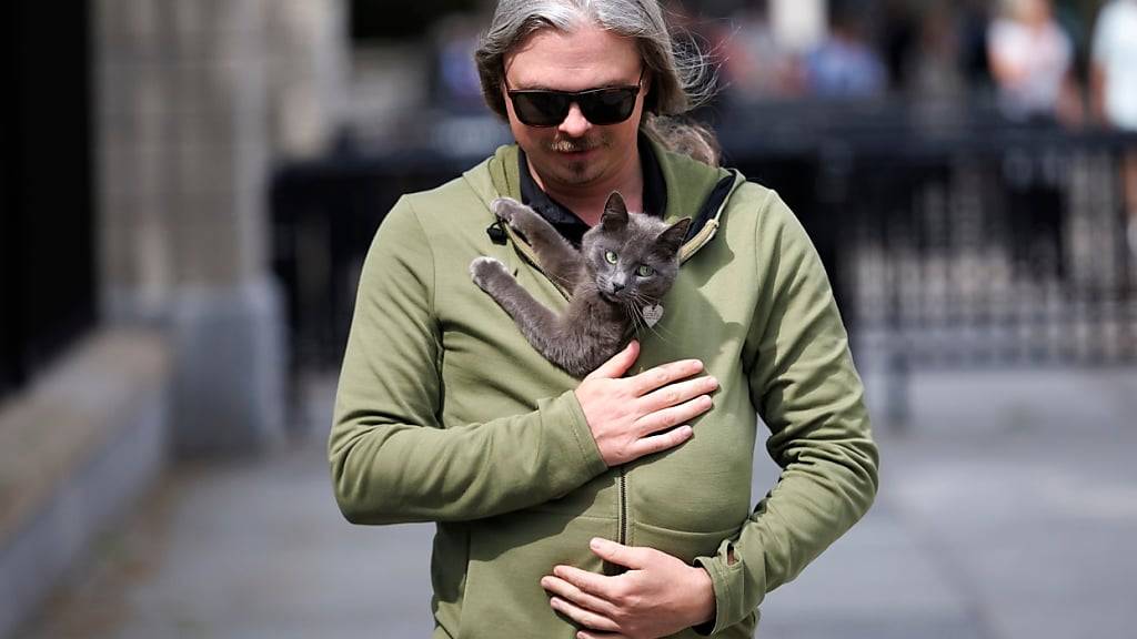 Alec Augustine trägt seine Katze Sophie unter seiner Jacke. Sophie hatte sich auf das Gelände des Weißen Hauses verirrt. Foto: Tom Brenner/AP/dpa