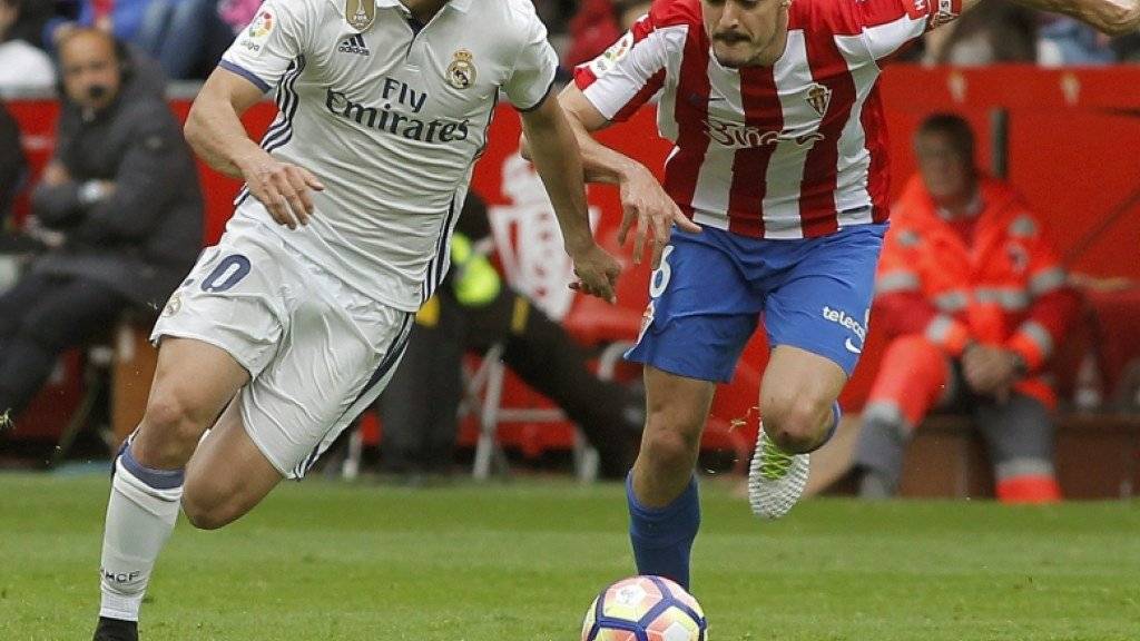 Real Madrids Marco Asensio enteilt im Mittelfeld dem Gijon-Spieler Sertio Alvarez