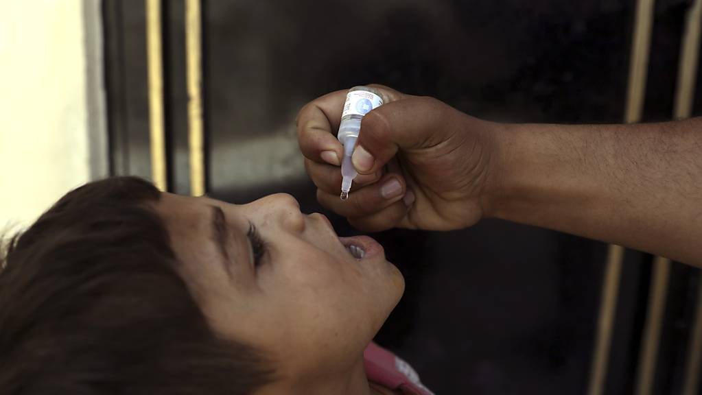 Ein Mitarbeiter des Gesundheitswesens in Kabul verabreicht einem Kind eine Polio-Impfung. 
