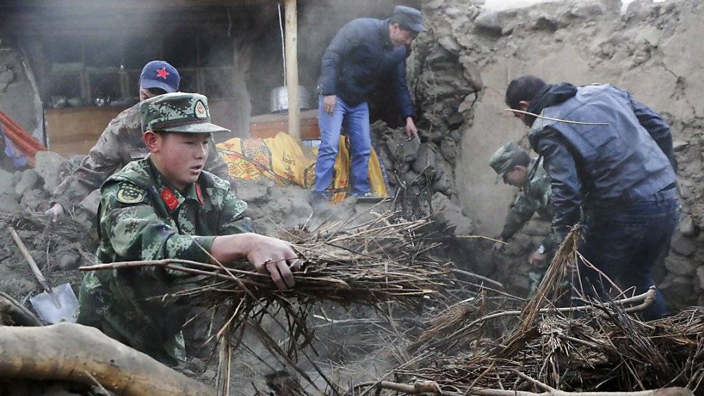 Im chinesischen Dorf Kuzigun suchen Rettungskräfte nach Überlebenden in einem eingestürzten Haus.