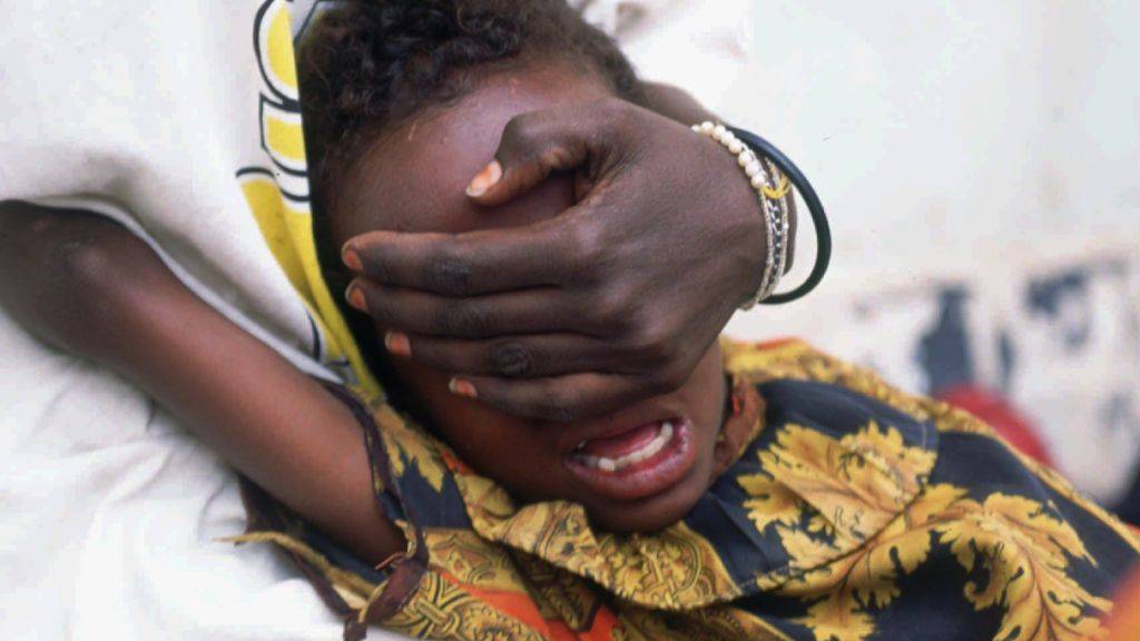 Ein sechsjähriges somalisches Mädchen schreit während der Beschneidung seiner Genitalien. Gehalten wird es von seiner 18-jährigen Schwester, damit es sich der peinigenden Prozedur nicht entziehen kann.
