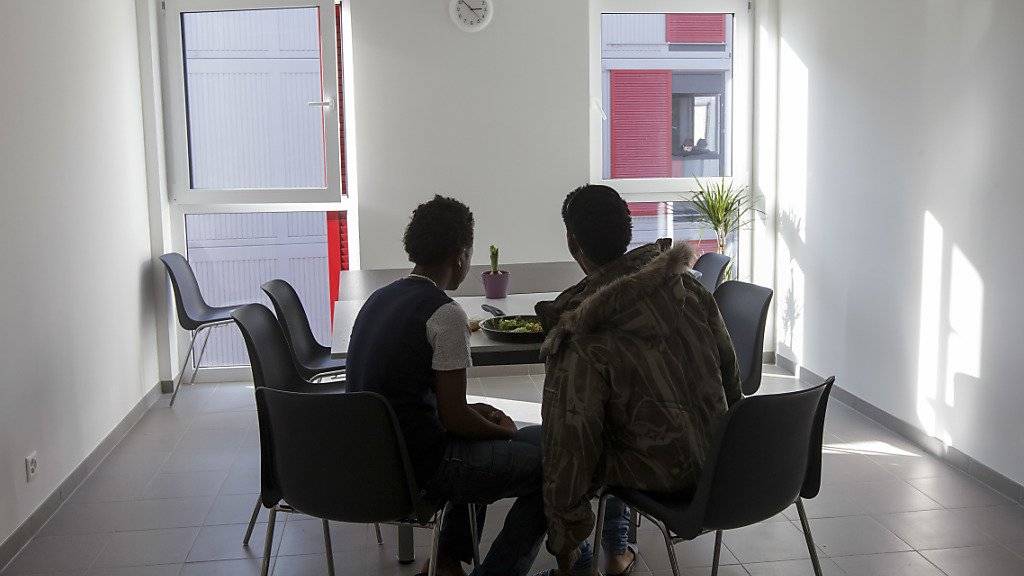 Zwei Flüchtlinge essen in einem Zentrum für junge Asylsuchende in Genf (Symbolbild).