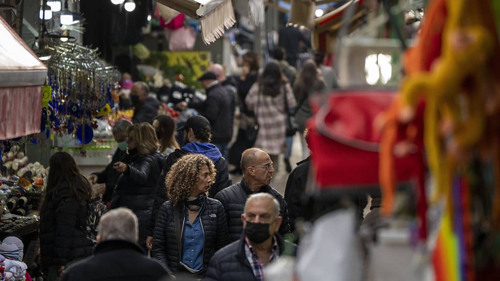 Menschen, einige mit Mund-Nasen-Schutz, kaufen auf einem Markt in Tel Aviv ein. In Israel hat die Zahl der Neuinfektionen mit dem Coronavirus einen Höchststand von 12 554 neu registrierten Fälle binnen 24 Stunden erreicht. Das teilte das israelische Gesundheitsministerium am Mittwoch mit. Foto: Ariel Schalit/AP/dpa