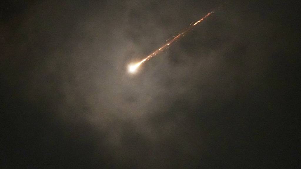 ARCHIV - Die Spur eines Geschosses ist durch die Wolken zu sehen, nachdem ein Raketenalarm nach Angriffen aus dem Iran in Jerusalem am frühen Morgen ausgelöst wurde. (zu dpa: «Trump kokettiert mit Machtwechsel im Iran») Foto: Ohad Zwigenberg/AP/dpa