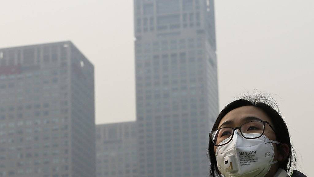 Peking im Smog: Wer auf die Strasse muss, trägt hier eine Maske zum Schutz vor dem Feinstaub.