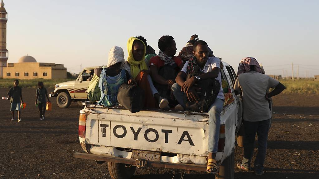 Äthiopische Flüchtlinge sitzen auf der Ladefläche eines Pick-ups. Nach Angaben des UN-Flüchtlingshilfswerks hat der wachsende Konflikt in Äthiopien dazu geführt, dass Tausende aus der Region Tigray in den Sudan geflohen sind. Äthiopiens Militär erhält in seinem Kampf gegen die Volksbefreiungsfront von Tigray (TPLF) nach deren Angaben auch Unterstützung aus Eritrea sowie einem nicht näher bezeichneten Staat außerhalb Afrikas. Foto: Marwan Ali/AP/dpa