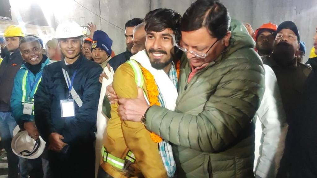 HANDOUT - Pushkar Singh Dhami (r), Ministerpräsident von Uttarakhand, begrüßt einen Arbeiter, der aus dem eingestürzten, sich im Bau befindenden, Tunnel gerettet wurde. Beim Tunnel-Drama in Indien sind alle 41 eingeschlossenen Arbeiter aus dem Berg befreit worden. Foto: Uncredited/Uttarakhand State Department of Information and Public Relations/AP/dpa - ACHTUNG: Nur zur redaktionellen Verwendung im Zusammenhang mit der aktuellen Berichterstattung und nur mit vollständiger Nennung des vorstehenden Credits