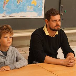 Dominik lernt seinen Sitznachbar kennen